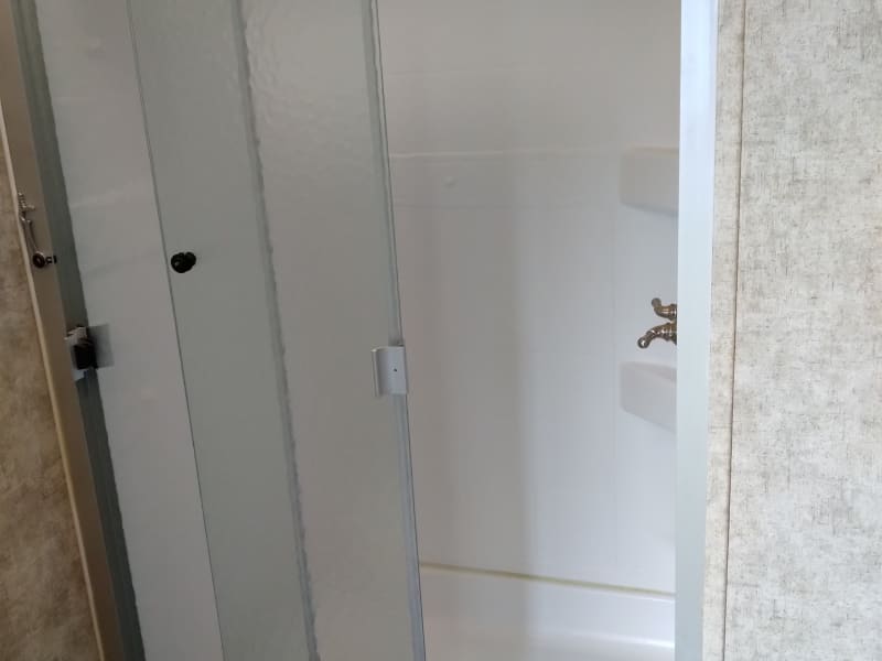 Shower door. The door has a lock that must be latched when traveling.
