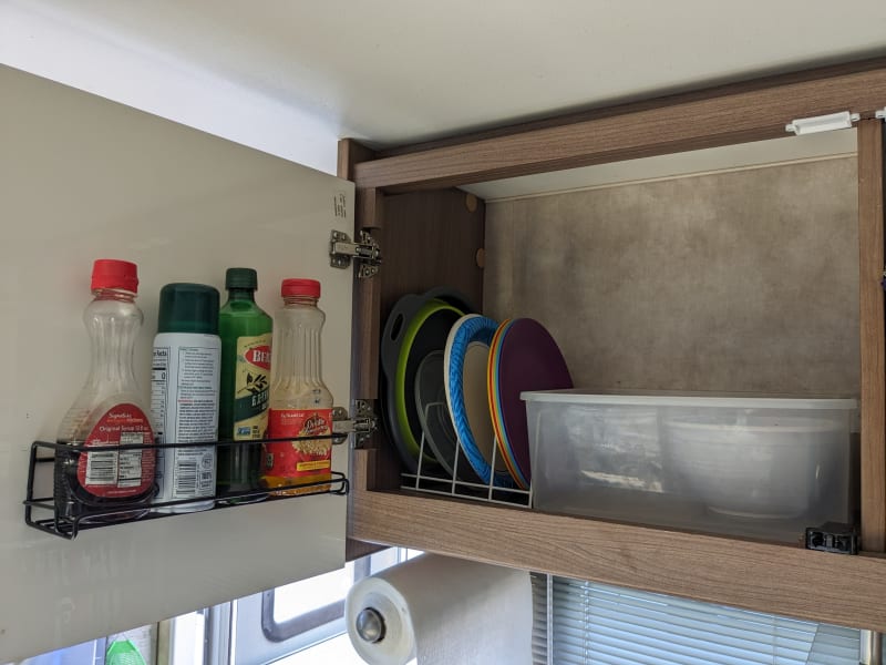 Above the sink plates, oils, syrup, and bowls.