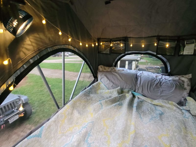 Roof top tent with provided battery-operated string lights a battery-operated mini fan and light.   (Bedding not included in rental.) 