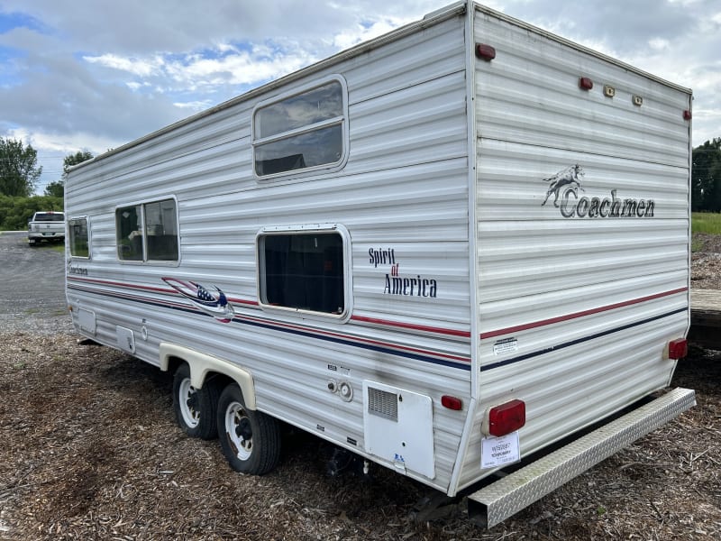 Left rear view with hot water tank access, electric and city water hookup and fresh water tank fill up and sewer hookup. 