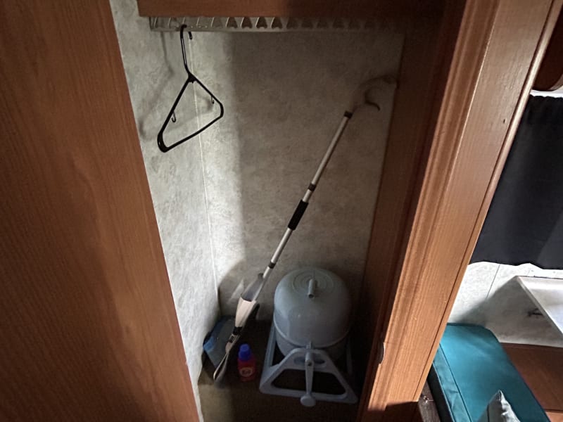 Storage closet with mop and manual washing machine. 