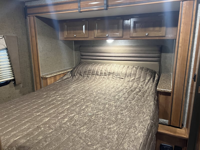 Queen-sized bed with storage above. Areas on both side w/ charging plugs for phones. Bedroom has a door for privacy and it's own entrance to bathroom.