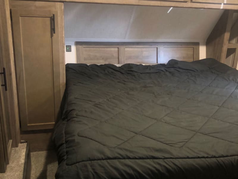 Master bed with a rv king size bed. The bed is very comfortable due to having a custom 3” foam mat