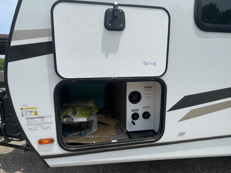 Hook up compartment.
Storage goes all across the RV for long items. Inside the compartment it has a light to help you find what you need.