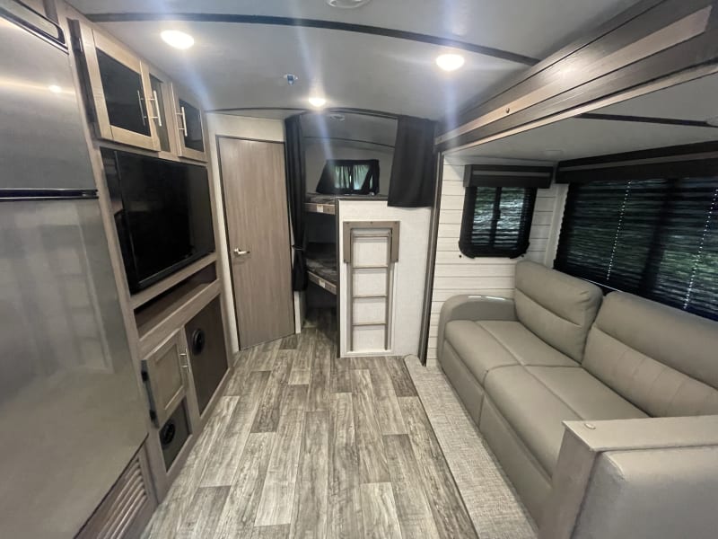 Living room area with couch (turns into full size bed). Smart TV that connects to the Bluetooth system of the RV. It’ll play inside and outside.