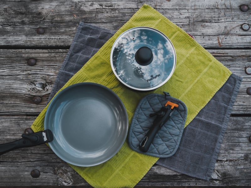 The galley is well equipped with cooking ware, dinnerware, kitchen towels, hot pads, dish soap, cleaning supplies, and a roll of paper towels.