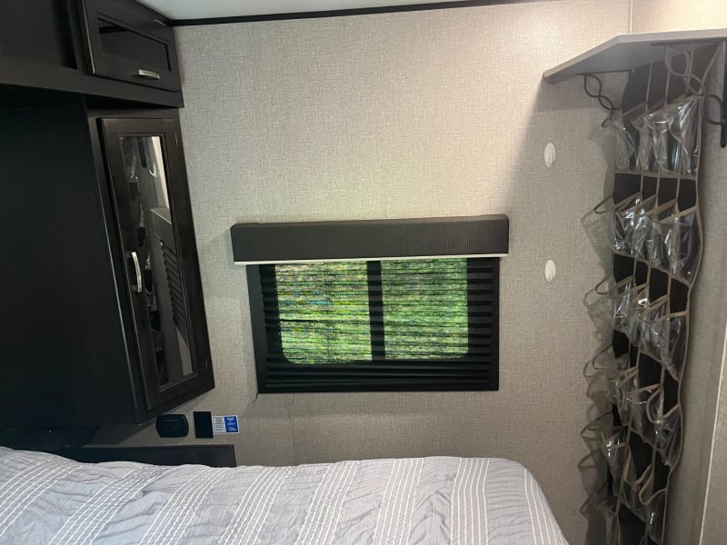 Master bedroom with queen size bed, fan included, and also clothes hangers.