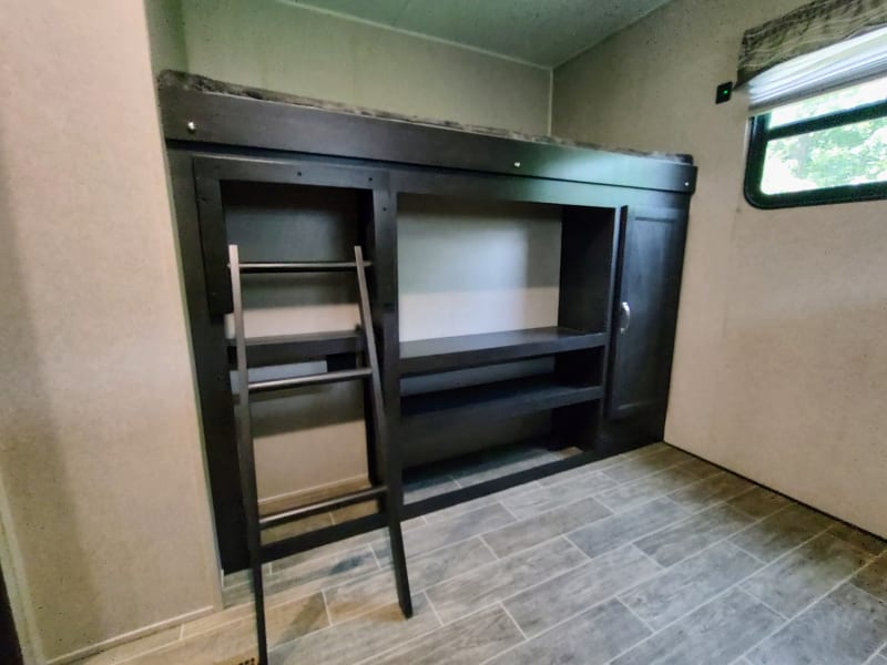 2nd bedroom with one bunk located above outdoor kitchen area.