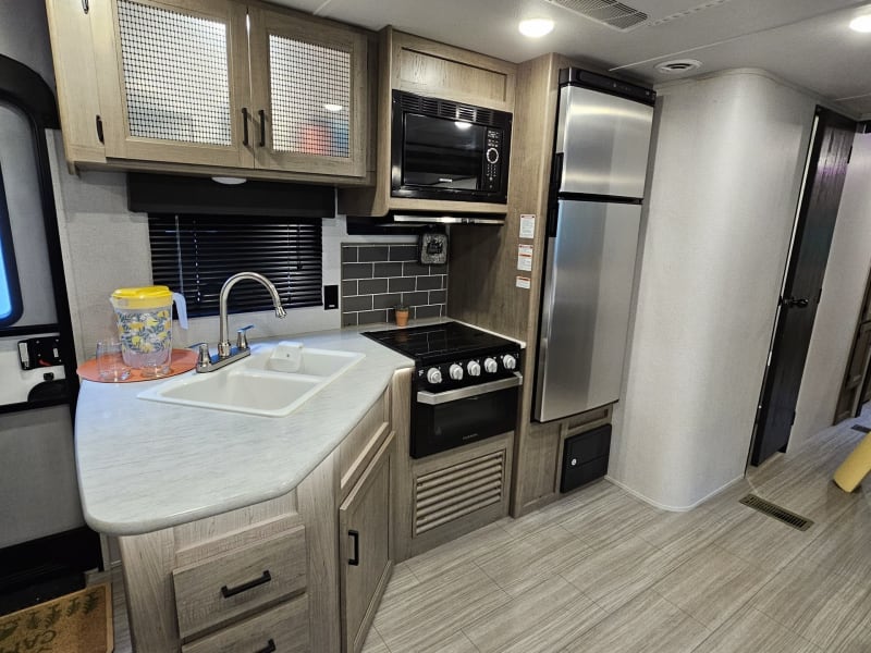 kitchen featuring double sink, large refrigerator/freezer, microwave and more