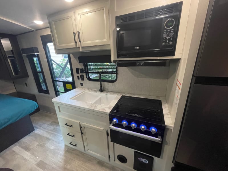 Fully equipped kitchen with 4 burners, microwave, double sink, fridge and freezer + plenty of storage. DInnerware for 6 included + cooking essentials.