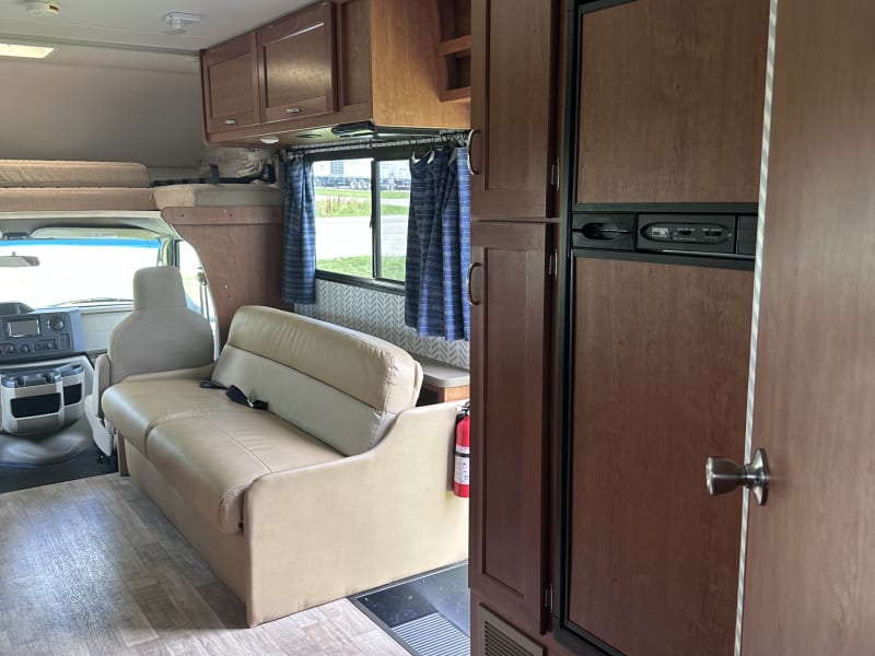 Fridge, Storage and pull out couch with seat belts.