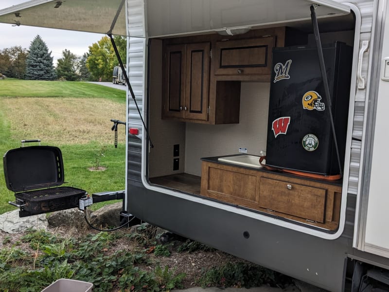 Outdoor kitchen with mini fridge, grill and sink. 
Portable Ice maker available in add ons. 