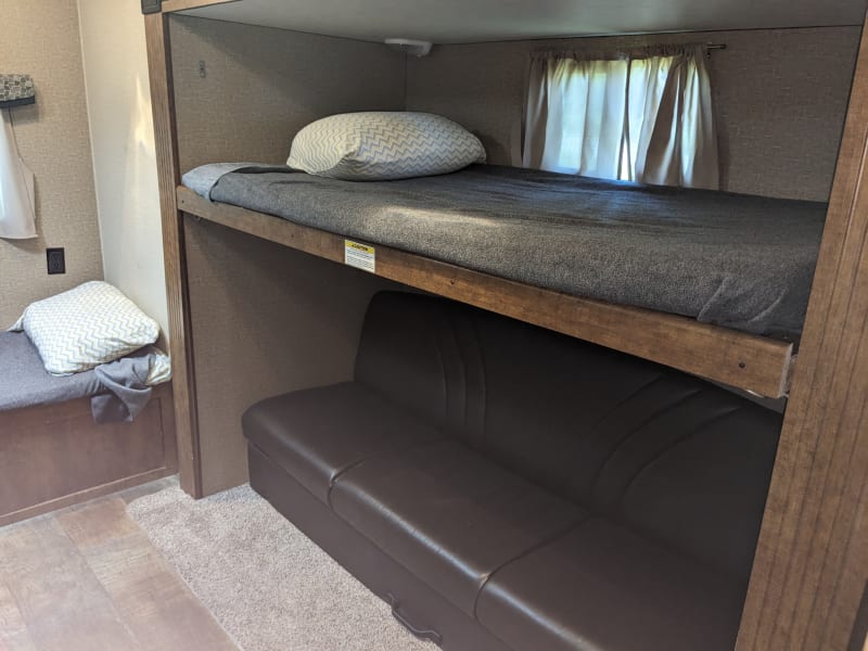 Upper bunk raises to allow room for sitting on couch. Couch folds into bed with additional trundle bed under couch. 