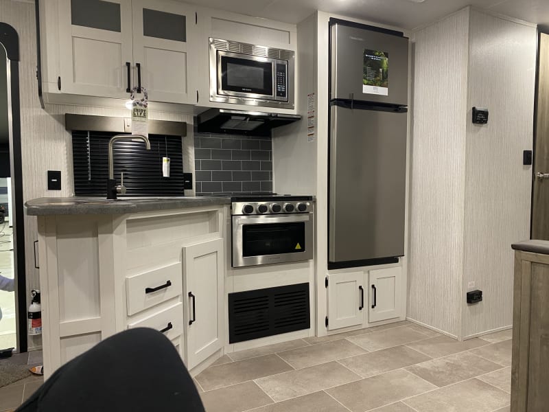Beautiful Kitchen area with stove, microwave and refrigerator 