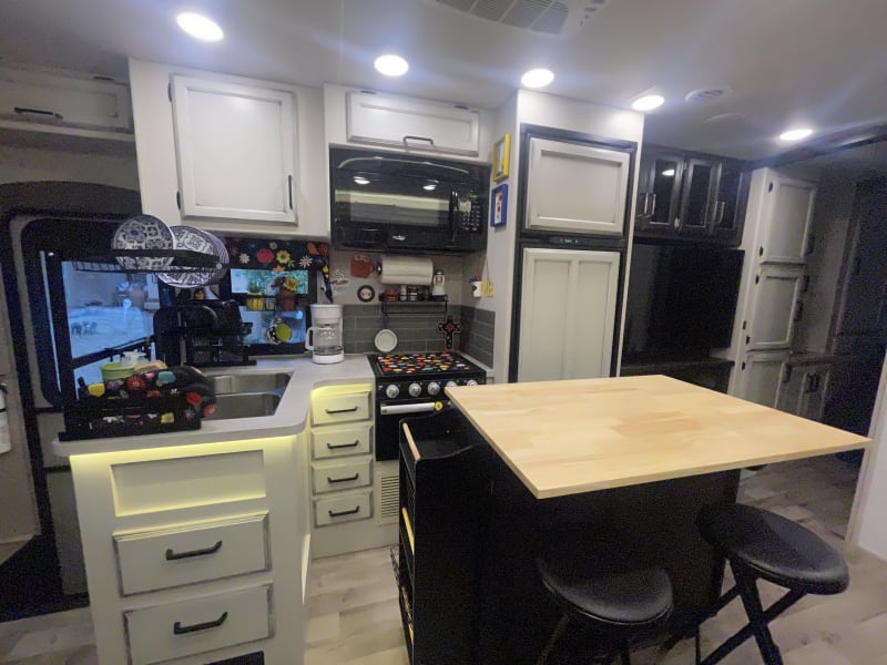 2 sink, microwave, midsized fridge, and kitchen island with option for extending top and 2 additional stools for seating 