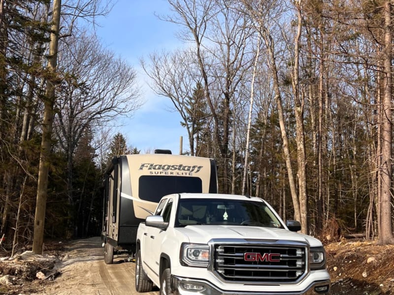Pictures a GMC 1500 towing closed camper down dirt road