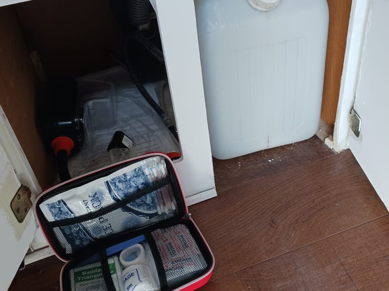 First aid kit and water tank under the sink.