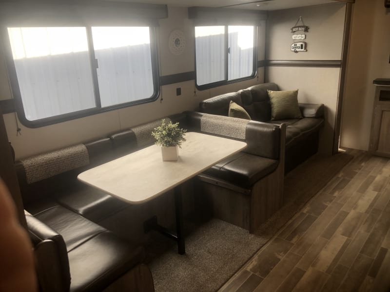 Large horseshoe dining table and seating that converts to double bed.  Jacknife couch folds out to bed.  All linens and pillows are provided.