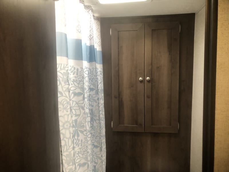 Bathroom storage.  Shower/bath tub to left.  