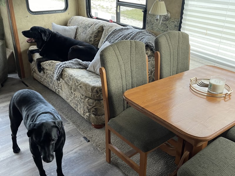 Not shown are the two recliners with a built in end table. There is a stove, microwave, and oven as well as a tv in the kitchen/living room area. 