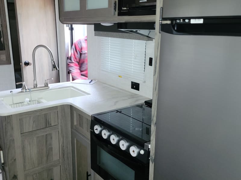 Kitchen with 
Sink, stove, microwave and mid sized refrigerator. 