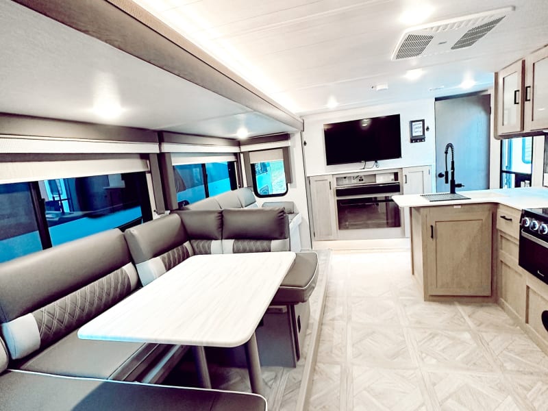 The dinette folds down into a bed. With flex seating the dinette seating can be expanded by flipping the seat back that separates the couch from dinette. The seat back can also be removed to create a bed the entire length of the slide.