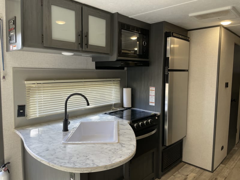 A well-organized layout makes fixing meals easy, while the large sink helps with clean-up. A three-burner propane gas stove and microwave provide options for quick snacks and full comfort meals.