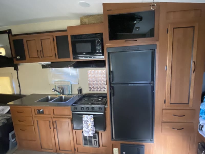 3 burner propane stove and oven. Electric/ propane fridge, microwave and double sink. 