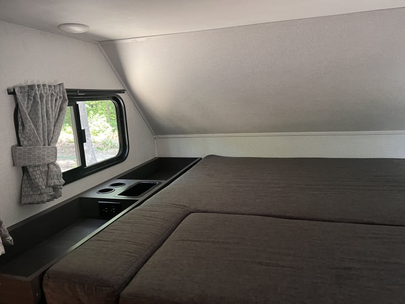 Above cab queen bed, storage, outlets, cup holders, tv, privacy curtain