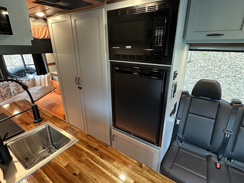 Refridgerator with small freezer
microwave that can air fry and broil.  Shower to the left behind the doors