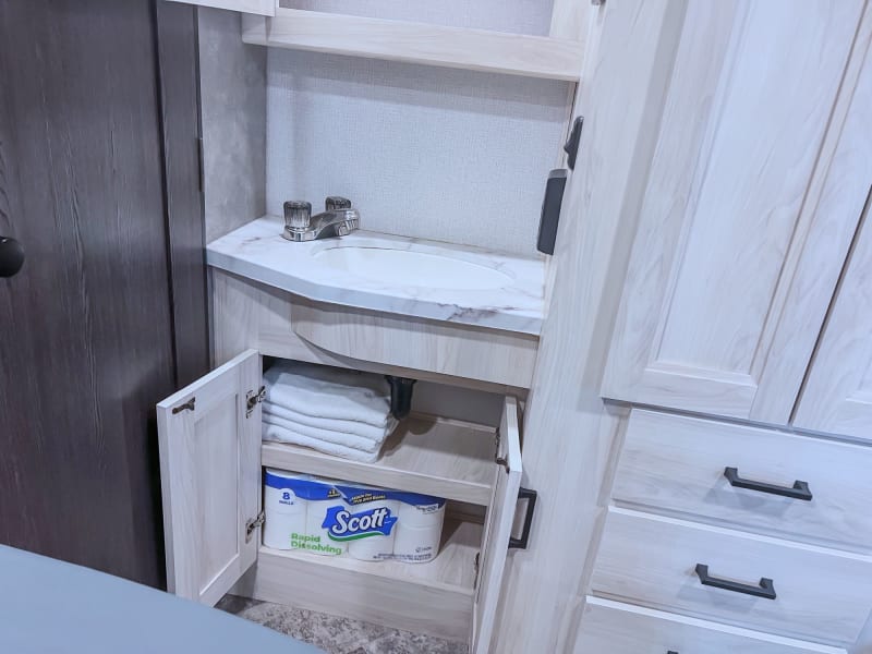 Lower bathroom cabinet, contains towels and RV toilet paper. 