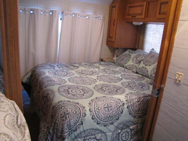 This is the main bedroom of the RV.  It features a queen-sized, upgraded mattress, a television, and ample storage for long stays. 