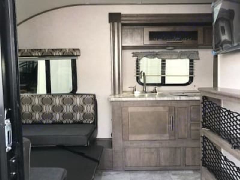 Sink, 4 burner stove, microwave, stocked with pots/pans, plates/bowls, utensils, cooking utensils, cups, coffee press.