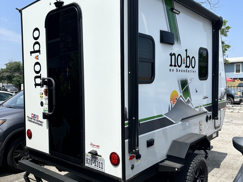 Back and side view of trailer. Includes an outdoor grill powered by propane and a powered awning along with exterior porch lighting that is controlled on the inside!