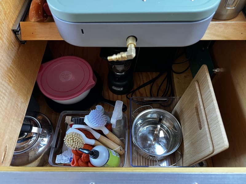 Mixing bowls, pan, cutting boards, and clean-up supplies are conveniently located inside the galley.