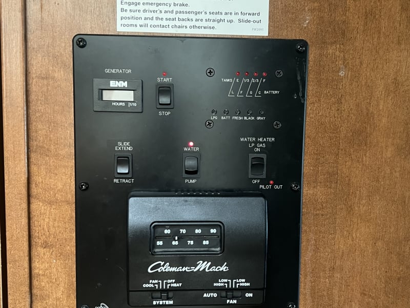 Control panel for generator, water tanks, main slideout, water pump, water heater, and air conditioner.
