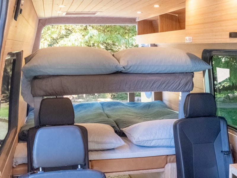 The rear dinette area easily converts into 2 beds, a Queen on bottom and Full on top. The top bed lowers at the touch of a button. Both beds come with a foam topper, linens, duvet, and pillows for a luxurious night's sleep! Open the screened windows and turn on the fan to keep things cool in the summer, or turn on the cabin heater for those cold fall and winter nights!