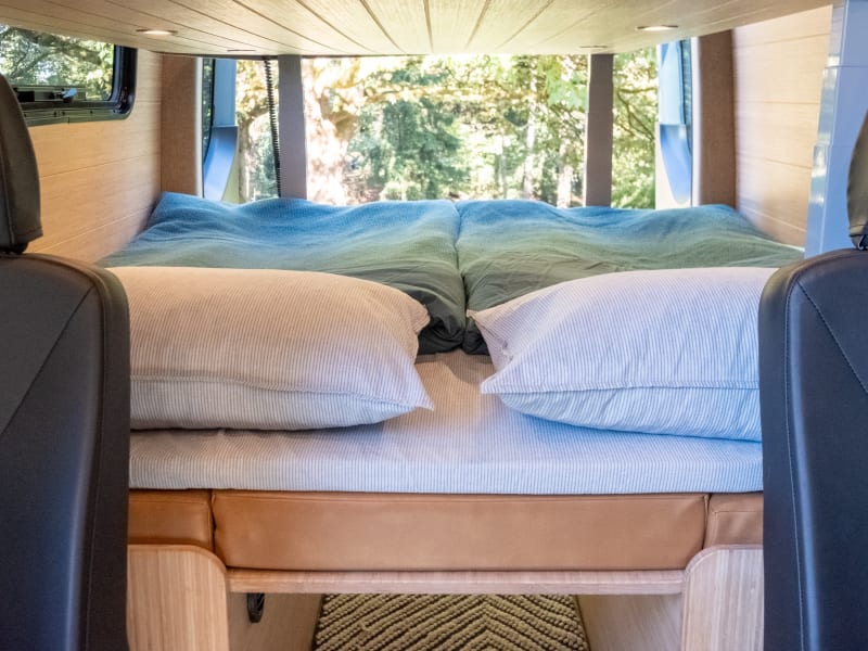 The lower Queen size bed comes with two European style duvets (one for each person), along with a comfortable foam topper and pillows.