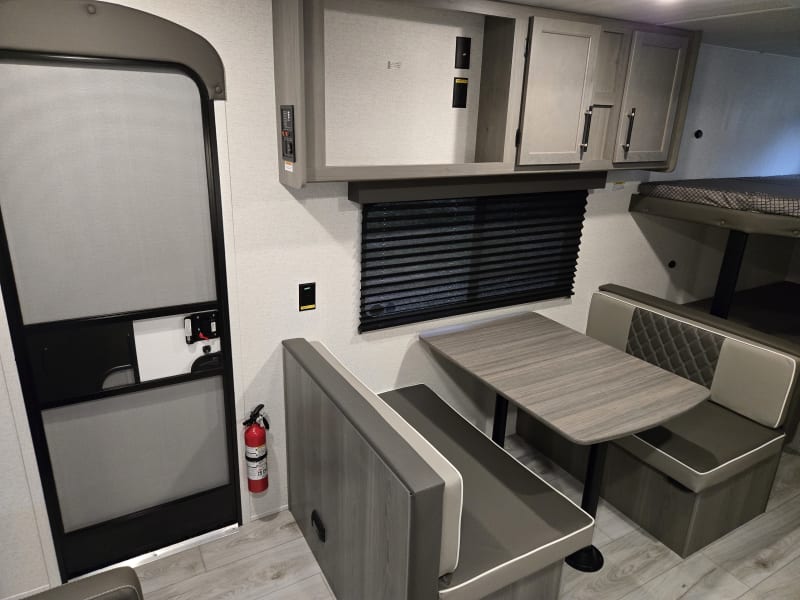Dinette/Conversion Bed with under seat storage. Above dining storage. TV has since been mounted.