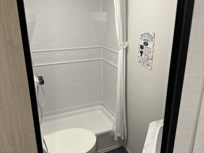 Private bath with shower (includes pull-down massaging showerhead), sink, storage and full-size toilet. Each rental includes basic toiletries and Scott's Brand RV toilet paper.