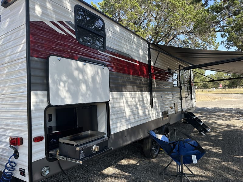Embrace your Adventure! This 32' travel trailer makes the perfect home-away-from-home. Large awning provides plenty of shade and the adjustable steps make for a very stable entry/exit. Cook up your favorite campsite meals and keep your favorite beverage(s) cold & close by in the 2nd fridge located in the outdoor kitchen!