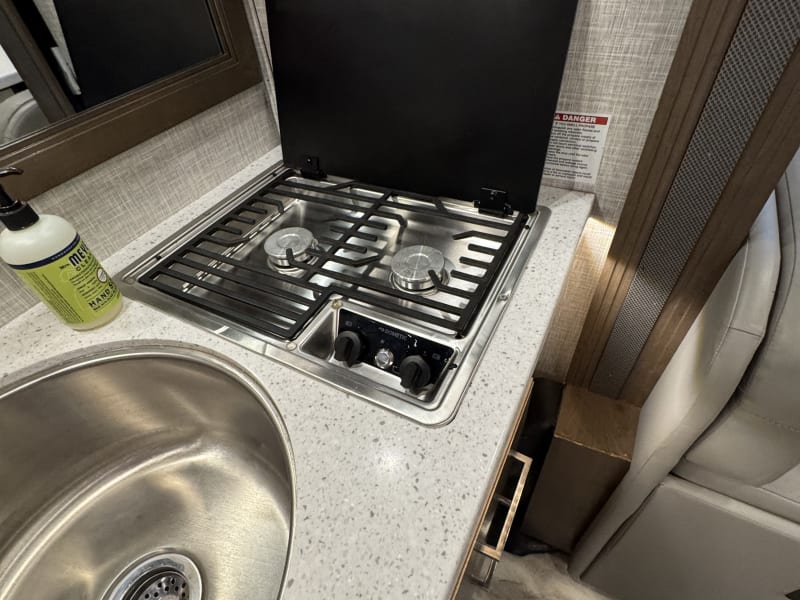 Close up of the stove top, full set of pots and pans provided. Dinner and salad plates, as well as bowls will be stocked as well. 