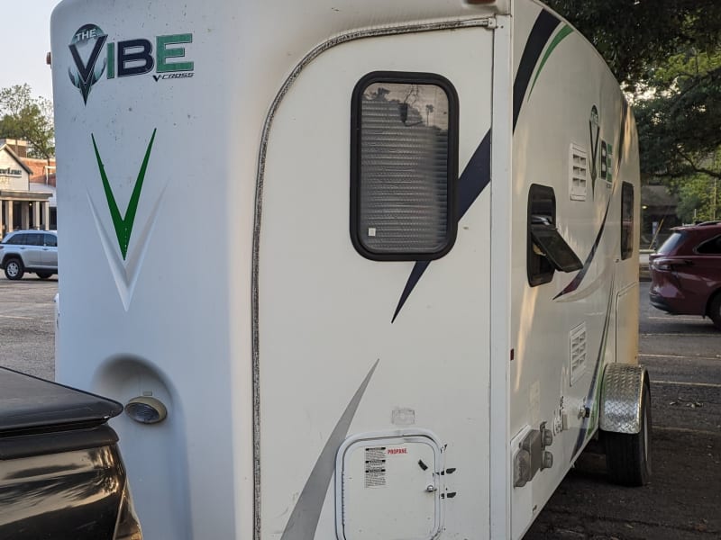 You can see some of the V shape towards the front hitch that gives this compact trailer a bit more interior space. The small door under the window houses the standard 20 pound propane tank, which is secured by a metal strap and buckle with a small lock on it to prevent potential theft.
