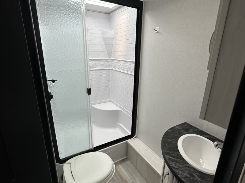 A bright and modern bathroom design with a large shower and natural light, perfect for cleaning up after a day of adventure.