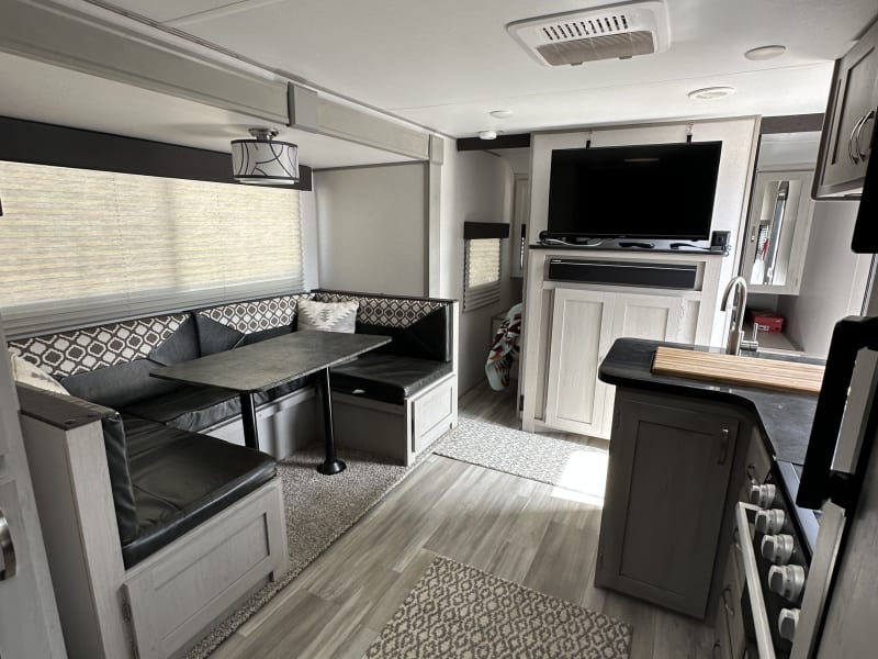 This open-concept kitchen and living area includes bunk beds, a spacious fridge, and everything you need for cooking and relaxing.