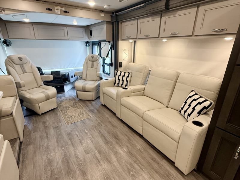 Reclining couch and captain chairs in the living room, plenty of room for the whole crew.
