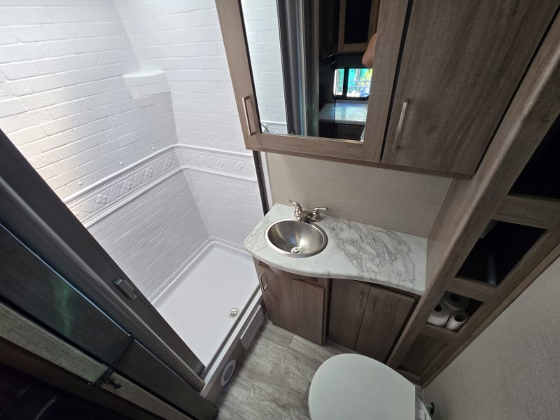 Modern and sleek bathroom with tons of storage, body wash, hand soap, toilet paper, and bath towels included