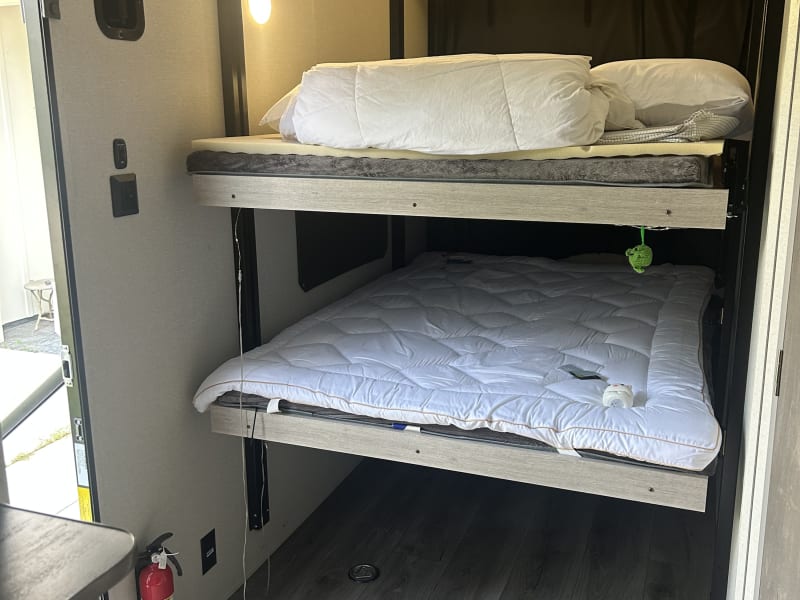 2 FULL size bunks that move up and out of the way with the press of a button.  This space can be used for storage, (it's actually a garage) and you can walk right out back to the drop down deck with railing and gate. 