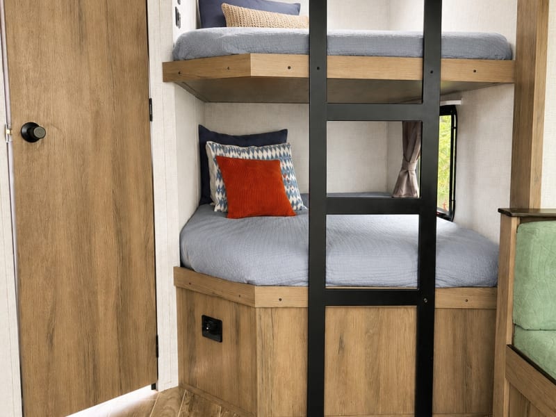 Double bunk beds with privacy window, ladder access, and storage below—ideal for kids or extra guests