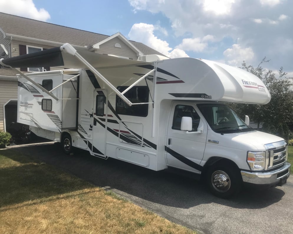 Thor 30’ Freedom Elite features an electric awning and one slide out on the passenger side. LED lights under the awning provide illumination when it’s campfire time. External TV is located behind passenger side cab.